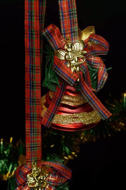 Campanas De Navidad Con Un Lazo Rojo Y Un Ngel Dorado Sobre Un Fondo