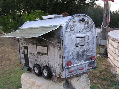 An Old Fashioned Mailbox Sitting On Top Of A Rock