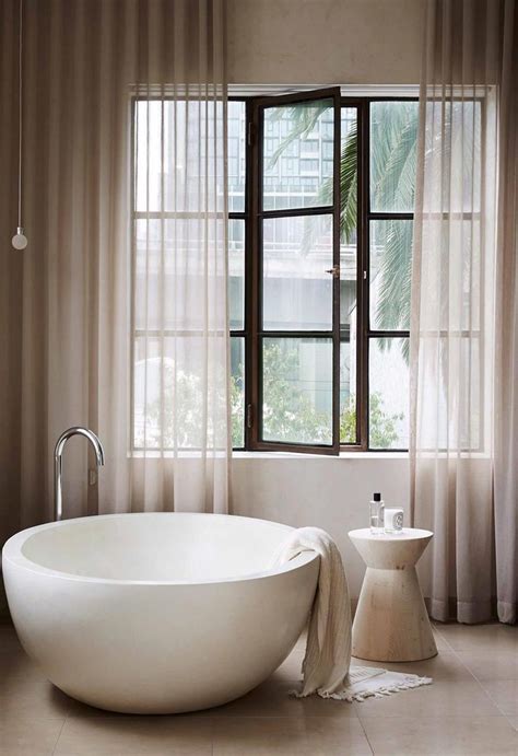 A Large White Bath Tub Sitting Next To A Window