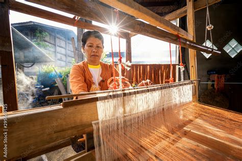 Traditional Isan Thai silk weaving. old woman hand weaving silk Akkanee ...