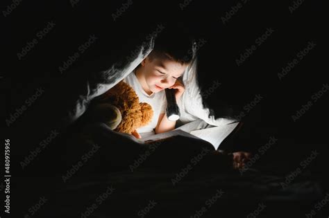 Child reading book in bed. Kids read at night. Little boy with fairy ...