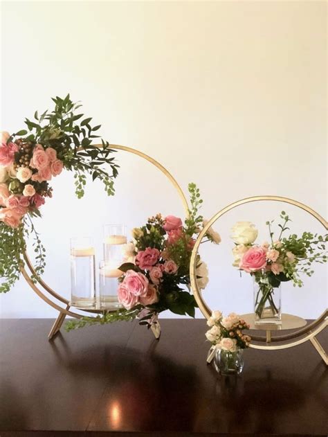 Two Vases With Flowers And Candles On A Table