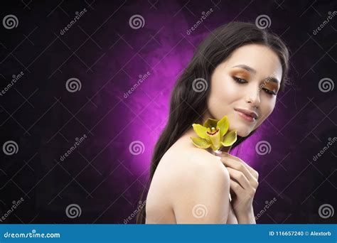 A Beautiful Brunette Nude Shoulders Girl Sensually Holds A Flower Of An