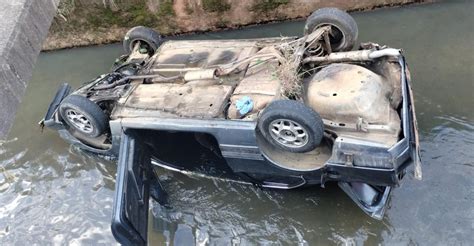 Carro cai em córrego e fica as rodas para cima em Juiz de Fora