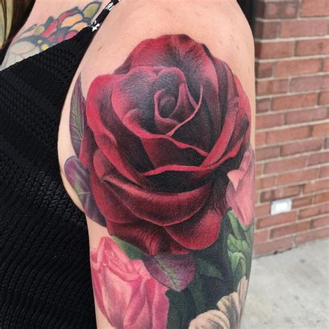 A Woman With A Rose Tattoo On Her Arm