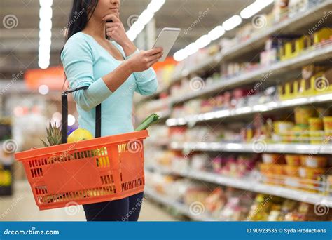 Woman With Food In Shopping Basket At Supermarket Stock Photo Image