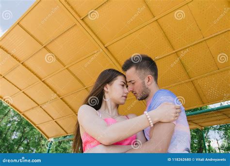 Young Couple Hugging And Smiling At Each Other Under A Canopy On The