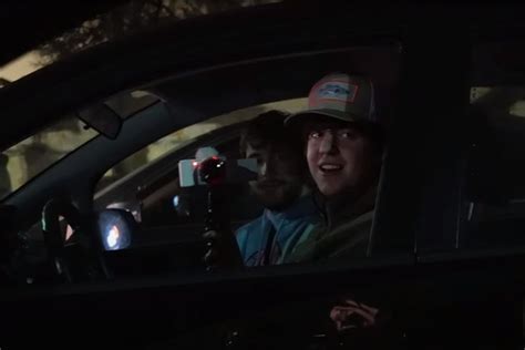 Two People Sitting In The Back Seat Of A Car