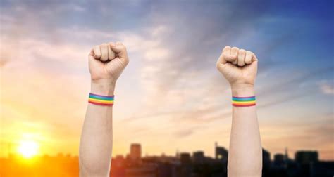 Premium Photo Hands With Gay Pride Rainbow Wristbands Shows Fist