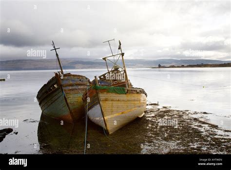 Two Beached Wrecked Abandoned Old Wooden Fishing Boats On The Beach