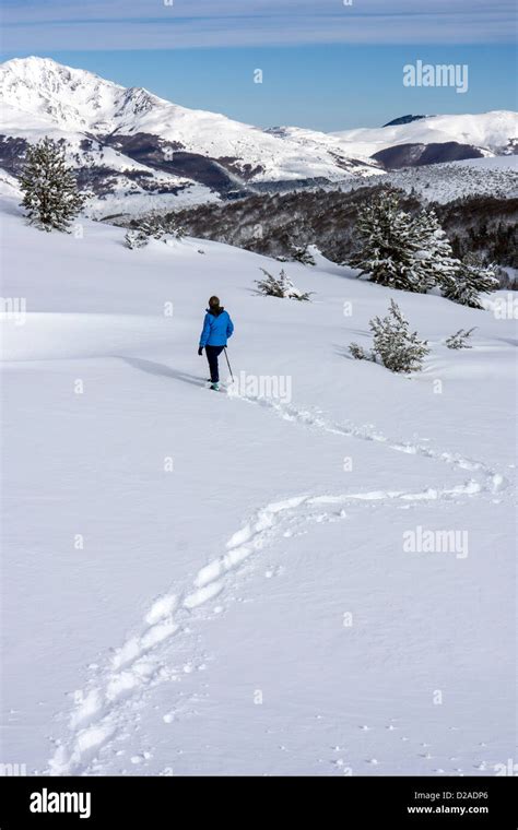 Female Dressed In Blue Snowshoeing At Beille Plateau French Pyrenees