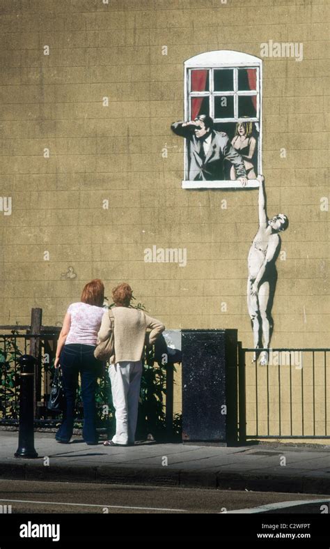 Wall Painting By Banksy Of Naked Man Hanging From Window Ledge Park