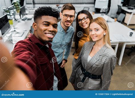 Camera Point Of View Of Smiling Multicultural Colleagues Taking Selfie