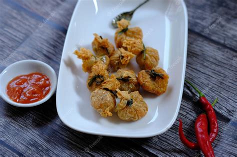 Premium Photo | A plate of fried fish with a red chili sauce siomay goreng pangsit goreng