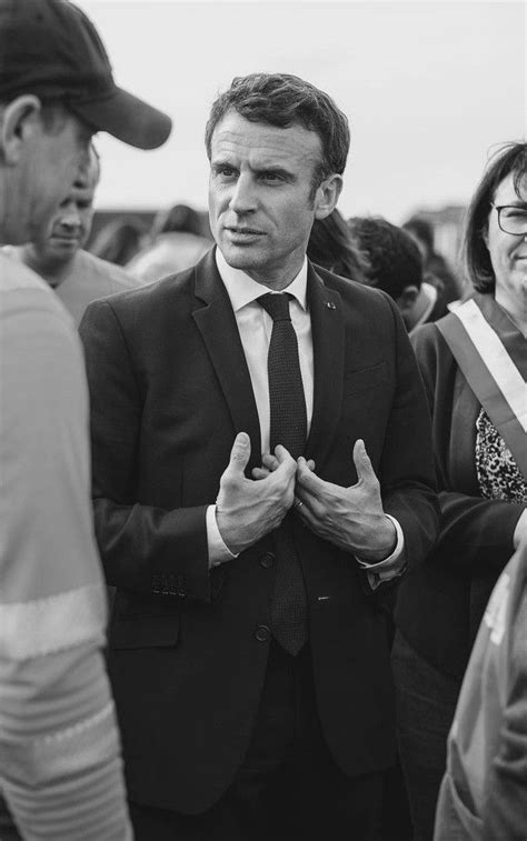 A Man In A Suit And Tie Standing With Other People