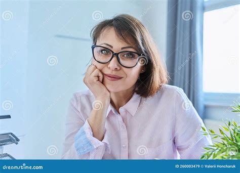 Webcam View Of Listening Mature Woman Sitting At Desk In Home Office