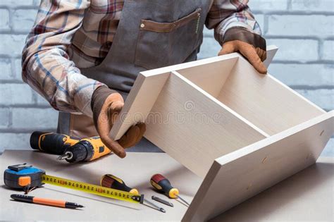 Carpenter Assembling Furniture On Desk Or Workbench Stock Photo