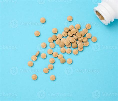 Yellow round pill for healthcare. Medical treatment, blue background