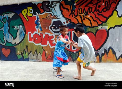 Street kids children are spinning in front of a graffiti wall at the ...