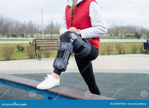 Woman Wearing Knee Brace Or Orthosis After Leg Surgery Working Out In