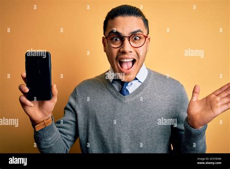 Young Brazilian Businessman Wearing Glasses Holding Smartphone Showing