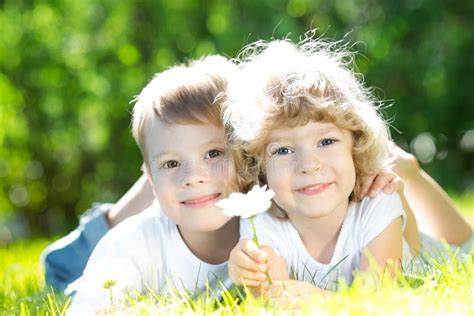 Petits Enfants Heureux Se Situant Dans L Herbe Aux Pieds Nus Aro De