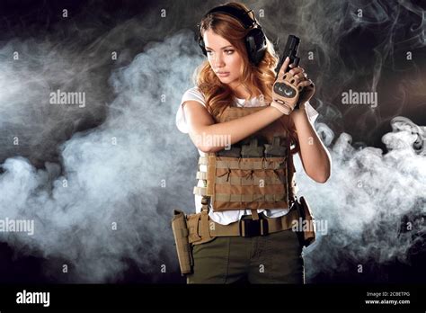 Armed Beautiful Blonde Woman Wearing Protective Headphones And Plate