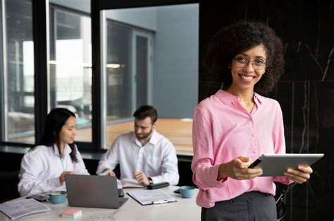 Mujer Que Usa Una Tableta Para Trabajar Mientras Sus Colegas Usan Una