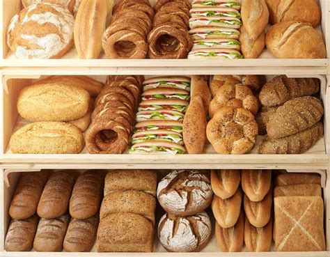 an assortment of breads and pastries displayed on shelves