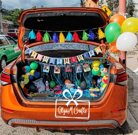 The Trunk Of An Orange Car With Decorations And Balloons