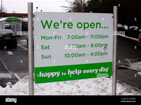 Asda store opening hours sign Stock Photo - Alamy