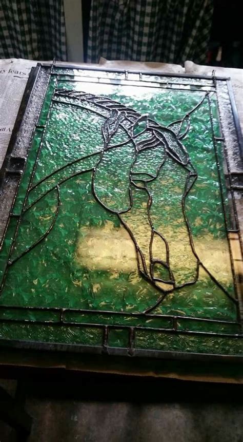 A Stained Glass Window Sitting On Top Of A Wooden Table