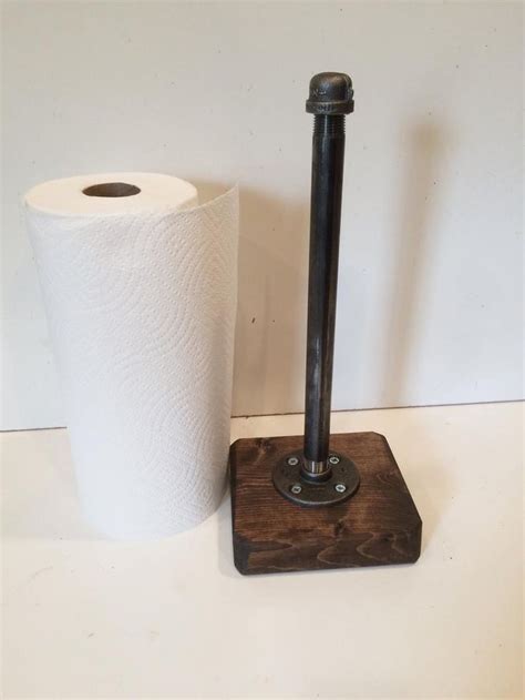 A Toilet Paper Dispenser Next To A Roll Of Toilet Paper On A Wooden Stand