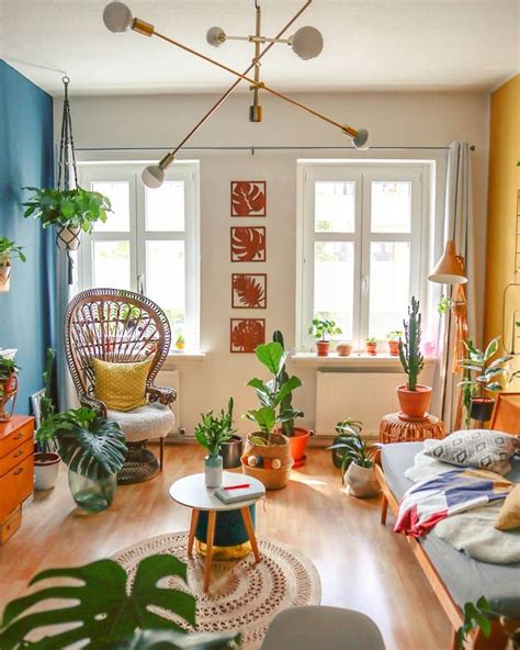 A Living Room Filled With Lots Of Plants Next To A Window And Wooden