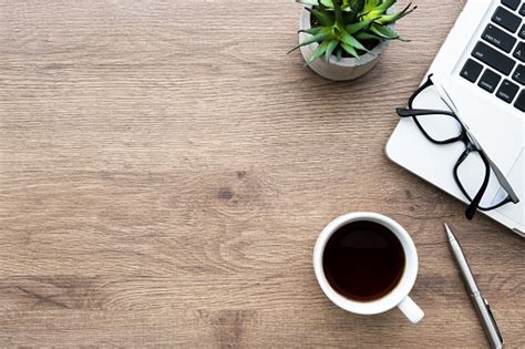 Wood Office Desk Table With Laptop Computer Cup Of Coffee And Supplies