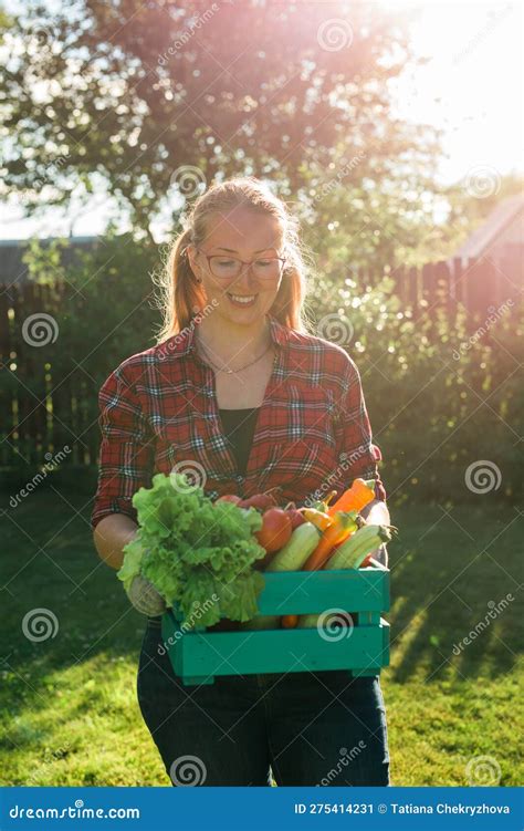 Female Farmer Carrying Box Of Picked Vegetables Garden And Harvesting