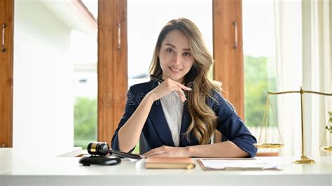 An Attractive Asian Female Lawyer Or Attorney Sits At Her Office Desk