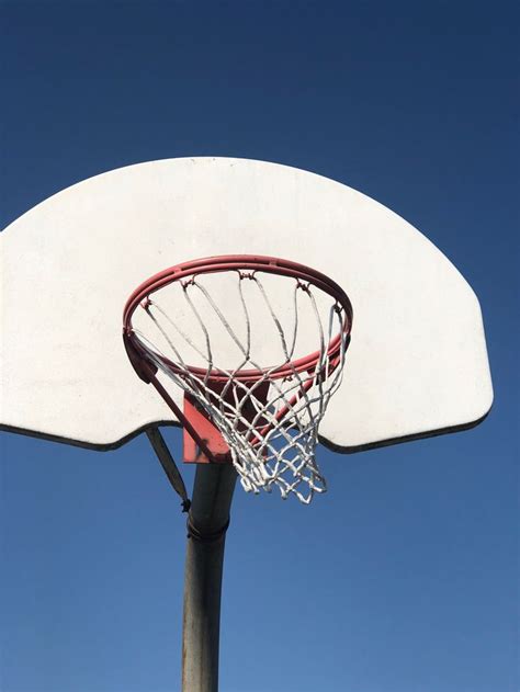 a basketball going through the rim of a basketball hoop with a clear ...