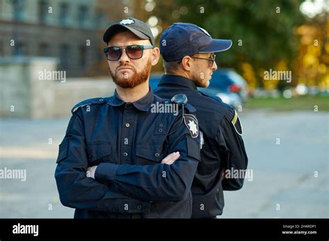 Two Male Police Officers Standing Back To Back Stock Photo Alamy