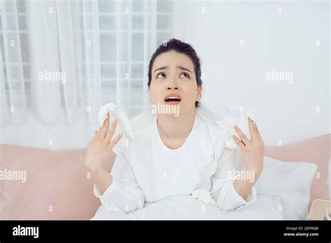 Sick Asian Woman Using A Tissue To Sneeze And Blowing Her Nose In