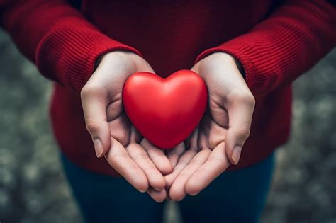 Premium Photo A Person Holding A Red Heart In Their Hands Generative AI