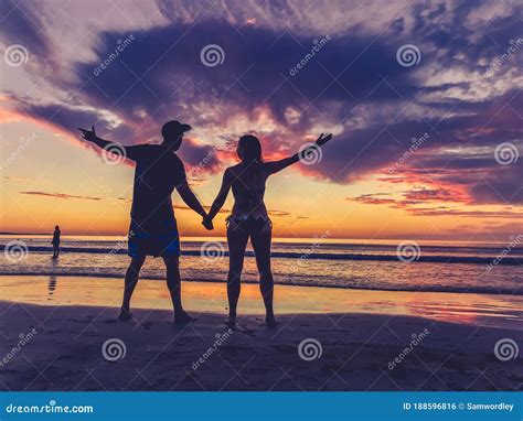 Siluetas De Pareja Enamoradas En La Puesta De Sol De La Playa Celebrando La Libertad Y El Amor