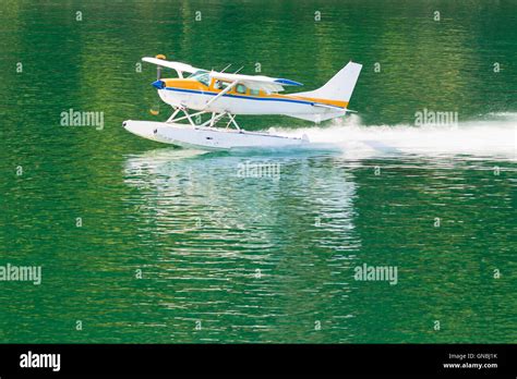 Aircraft seaplane taking off on calm water of lake Stock Photo - Alamy