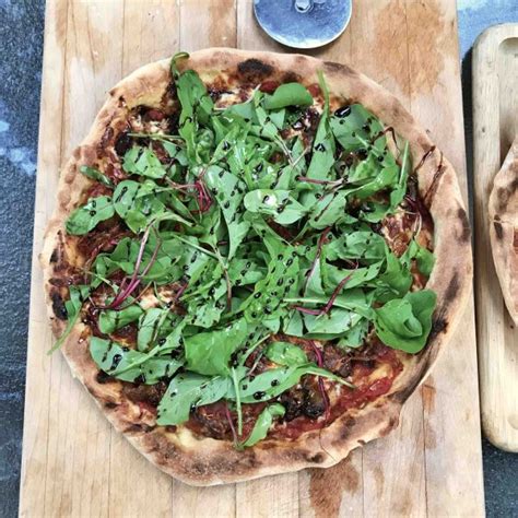 Pizza roquette et prosciutto sur croûte de purée d ail noir La terre du 9