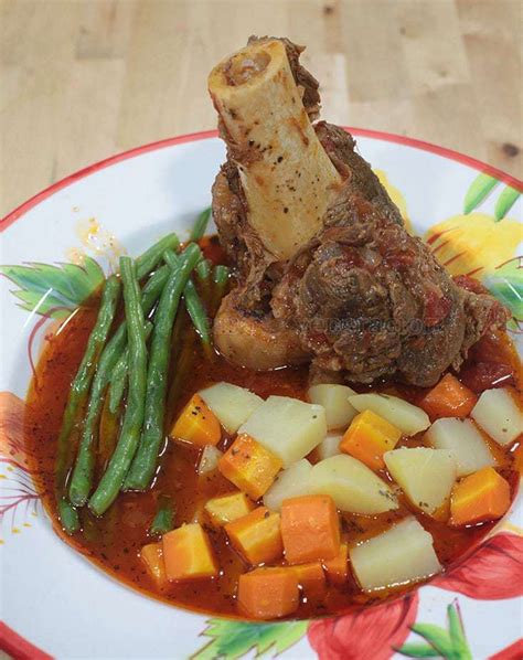 Bone-in beef shank is slow cooked in tomato sauce and served with ...