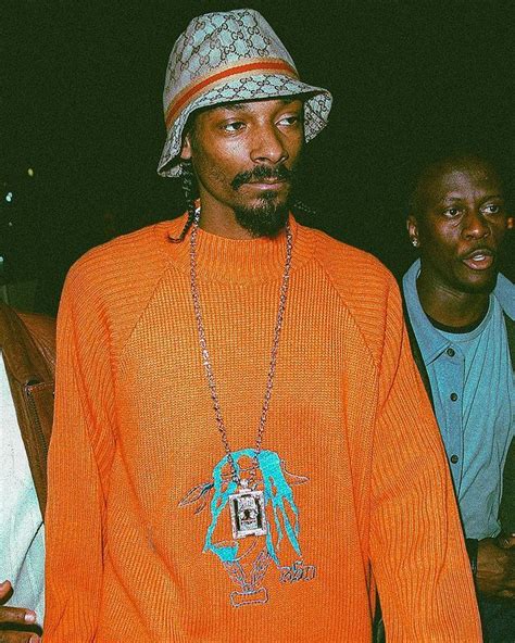 A Man Wearing An Orange Sweater And Hat