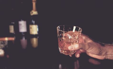 Premium Photo Cropped Hand Of Man Holding Whiskey Glass On Table