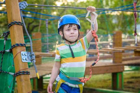 Menino Bonito Pequeno Que Aprecia A Atividade Em Um Parque De Escalada