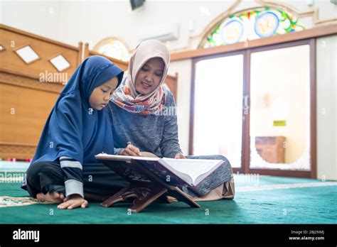 Muslim Young Female Teacher Teach Her Student To Read Quran In The