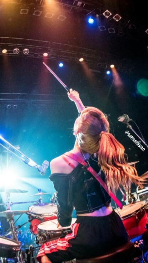 A Woman With Long Hair Playing Drums On Stage